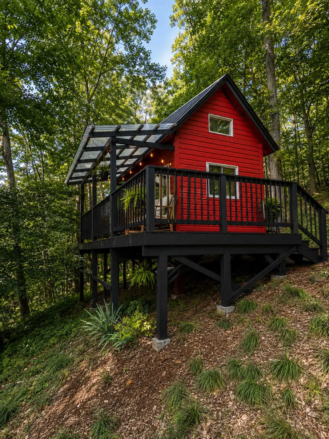 The Creekside Cabin, a small red cabin at the edge of the woods